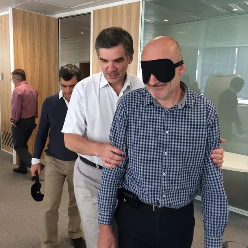 dinámica de consultoría para equipos en una sala un hombre con ojos tapados siendo guiado